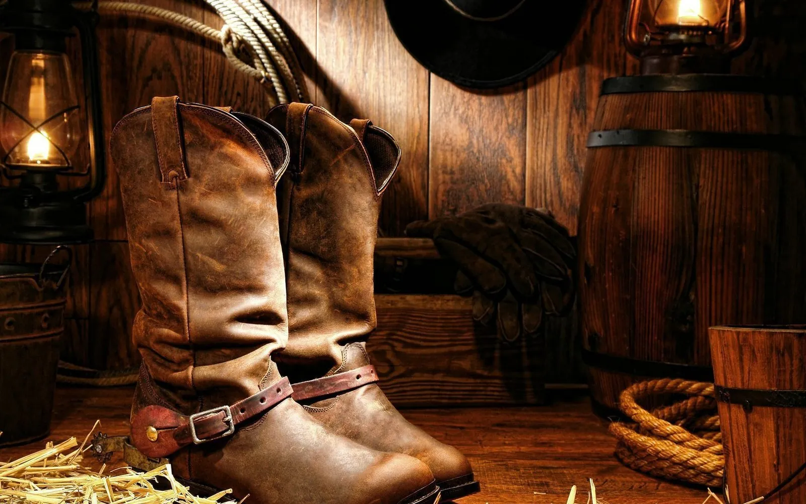 Cowboy boots and a saddle in a barn