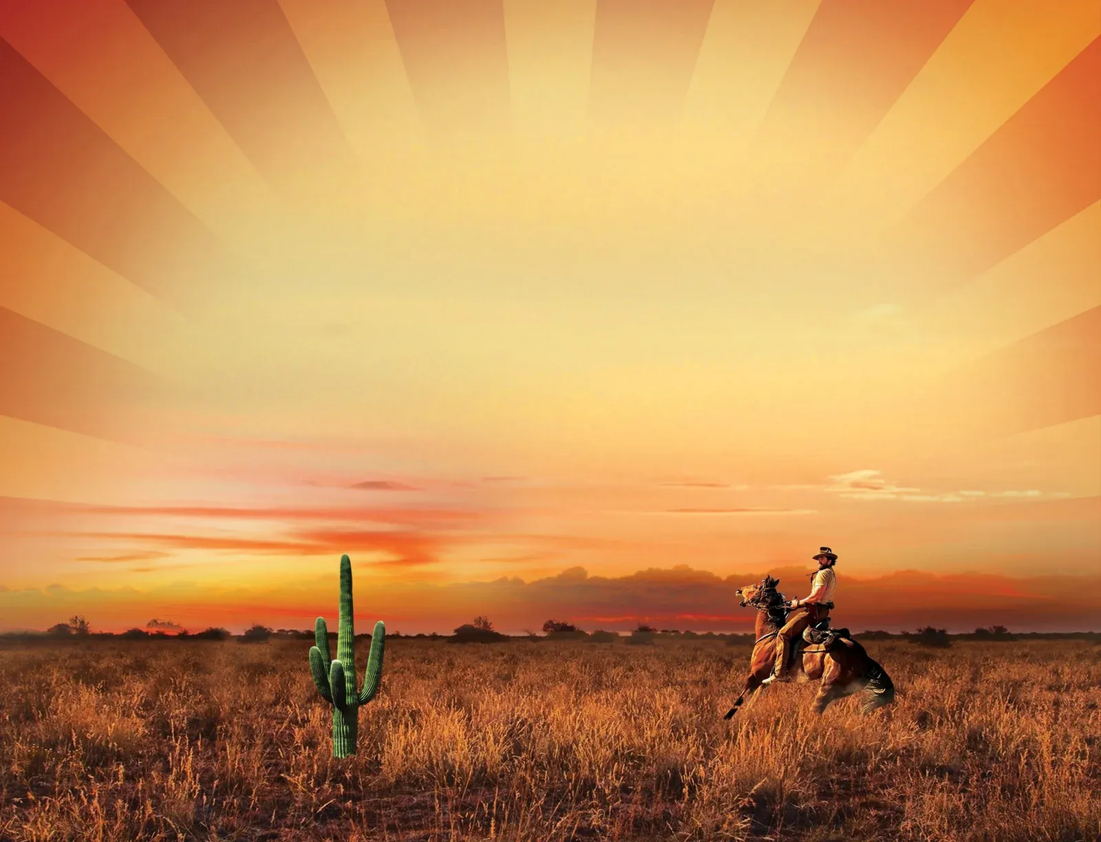 A cowboy riding across the desert at sunset