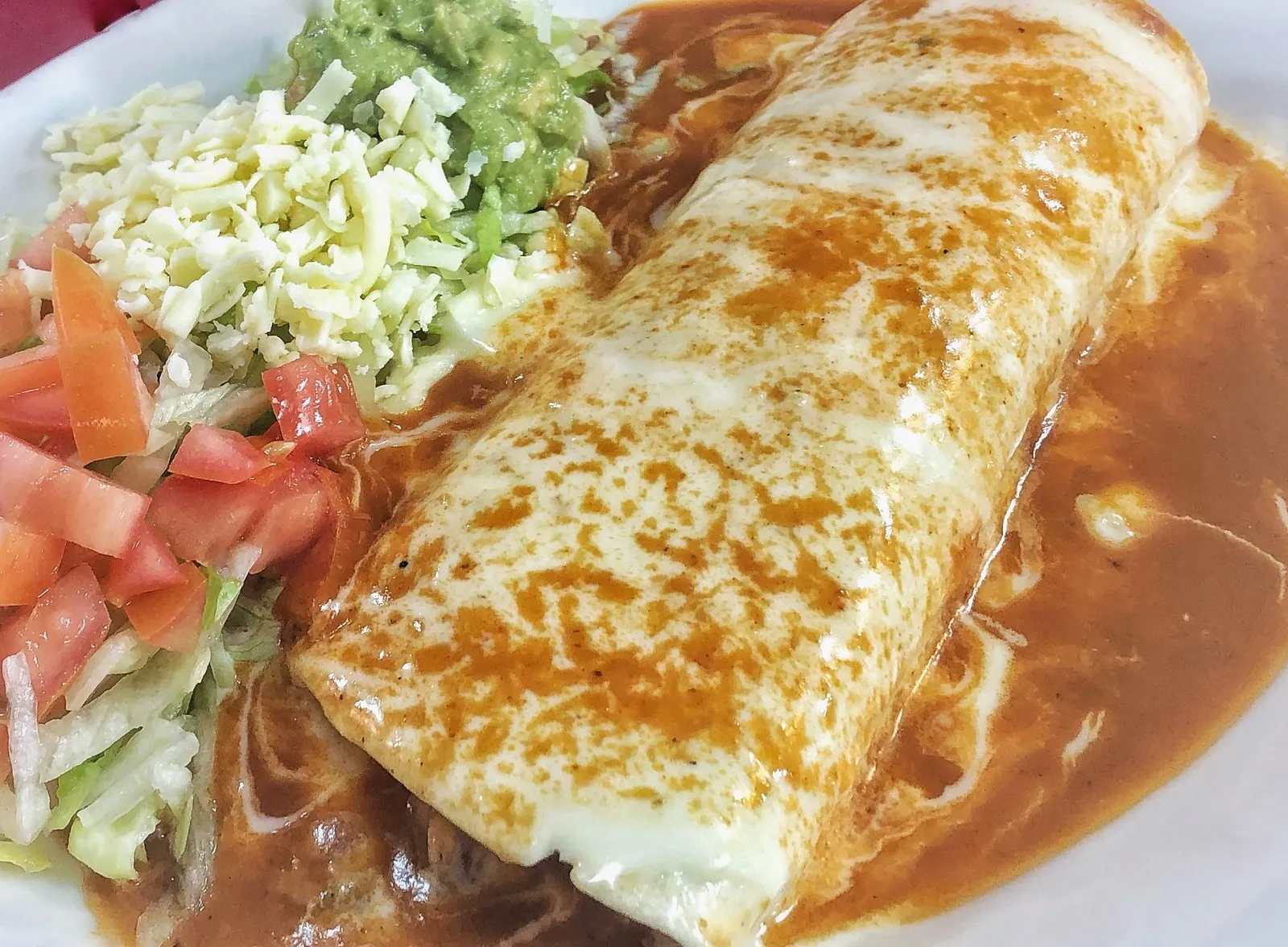 A smothered burrito with cheese sauce